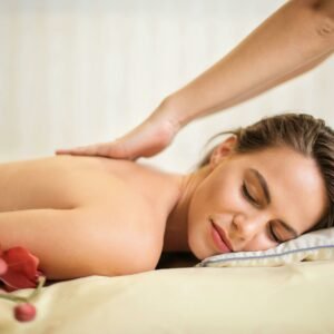 A serene spa scene featuring a woman receiving a therapeutic massage, surrounded by soothing elements.