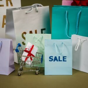 A mix of colorful shopping bags and a small cart displaying a discount gift.